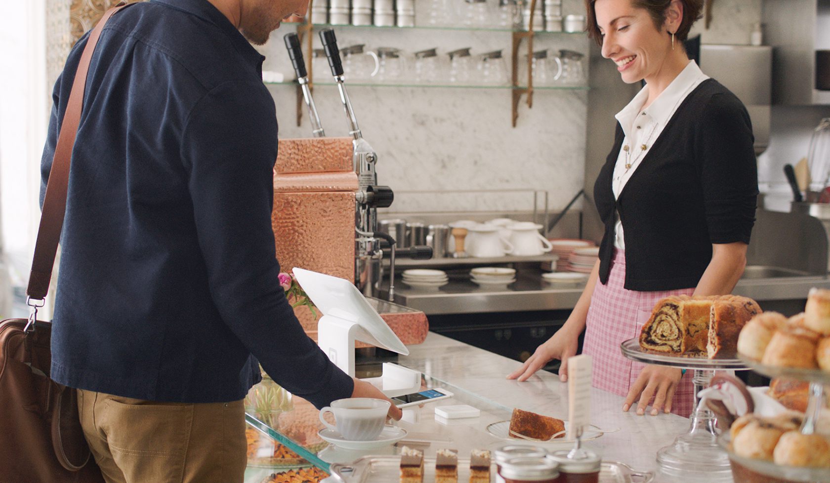 Image of man paying with Apple Pay at counter