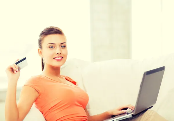 Женщина с ноутбуком, показаны кредитной карты на дому — стоковое фото