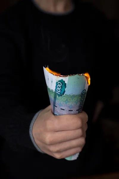 Пакет горящих рублей в руке человека — стоковое фото