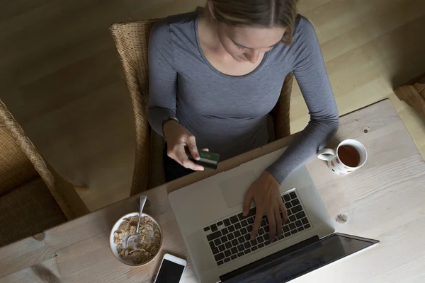 Женщина, используя ноутбук, чтобы сделать карты оплаты — стоковое фото