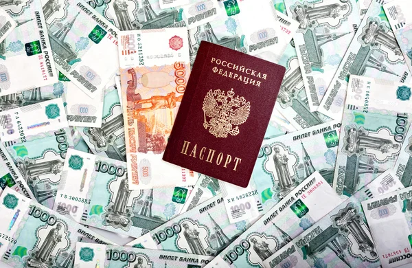 Деньги и Российской банкноты номиналом один и пять тысяч в фоновом режиме. Паспорт РФ — стоковое фото