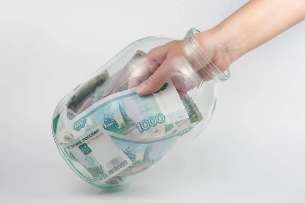 Рука вынимает стекла трехлитровую банки тысяч российских рублей — стоковое фото